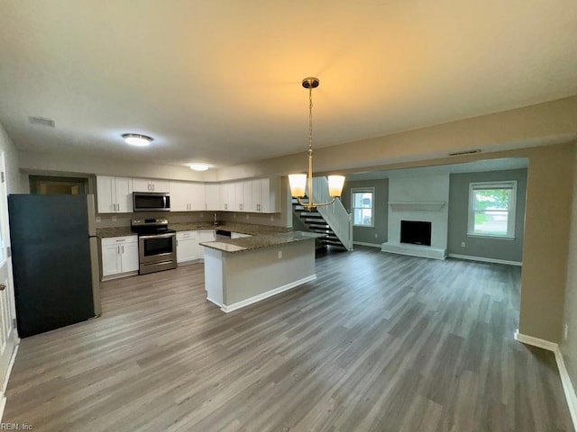 2020 Lyndora Rd, Virginia Beach, VA 23464 - kitchen featuring appliances with stainless steel finishes, white cabinets, open floor plan, wood finished floors, and decorative light fixtures