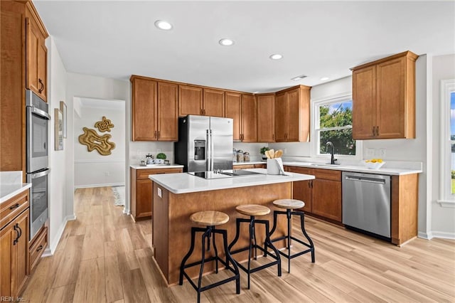1545 Lake James Dr, Virginia Beach, VA 23464 - kitchen with appliances with stainless steel finishes, light wood-style flooring, a kitchen bar, brown cabinets, and recessed lighting