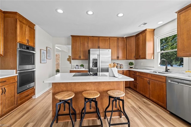 1545 Lake James Dr, Virginia Beach, VA 23464 - kitchen with appliances with stainless steel finishes, light wood-style floors, a breakfast bar, light countertops, and recessed lighting