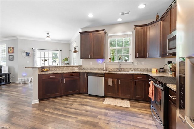 4202 Ravine Gap Dr, Suffolk, VA 23434 - kitchen featuring stainless steel appliances, a peninsula, ornamental molding, healthy amount of natural light, and dark wood finished floors
