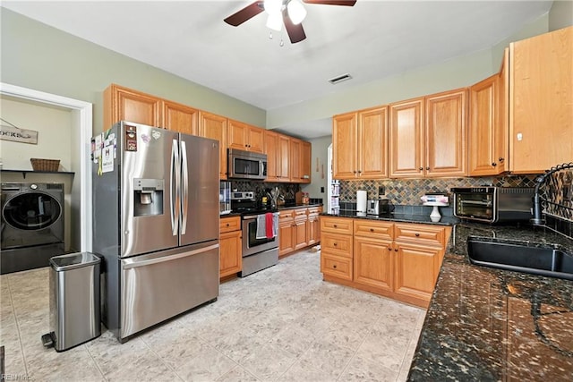 315 Sawmill Arch, Chesapeake, VA 23323 - kitchen with appliances with stainless steel finishes, washer / dryer, backsplash, a ceiling fan, and dark stone counters