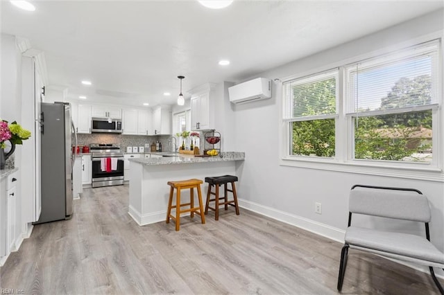 5016 Madeira Rd, Virginia Beach, VA 23455 - kitchen featuring appliances with stainless steel finishes, a wall unit AC, a peninsula, white cabinets, and recessed lighting