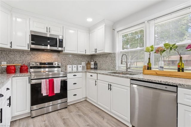 5016 Madeira Rd, Virginia Beach, VA 23455 - kitchen with stainless steel appliances, white cabinets, light wood-type flooring, backsplash, and recessed lighting