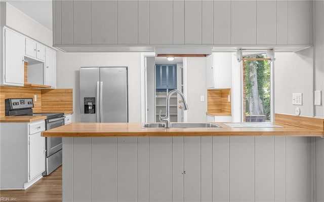5991 Clear Springs Rd, Virginia Beach, VA 23464 - kitchen featuring appliances with stainless steel finishes, white cabinets, wood counters, dark wood finished floors, and a peninsula