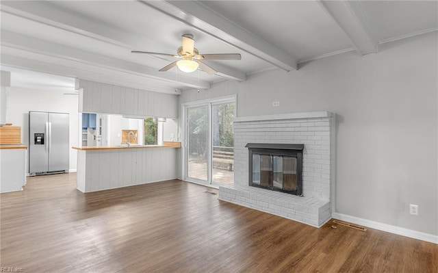 5991 Clear Springs Rd, Virginia Beach, VA 23464 - unfurnished living room with a ceiling fan, wood finished floors, beam ceiling, and a brick fireplace