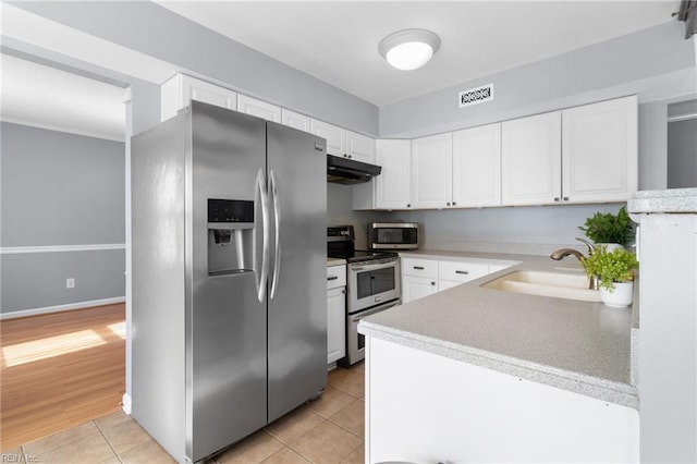1760 Moonstone Dr, Virginia Beach, VA 23456 - kitchen featuring stainless steel appliances, under cabinet range hood, white cabinetry, light tile patterned floors, and light countertops