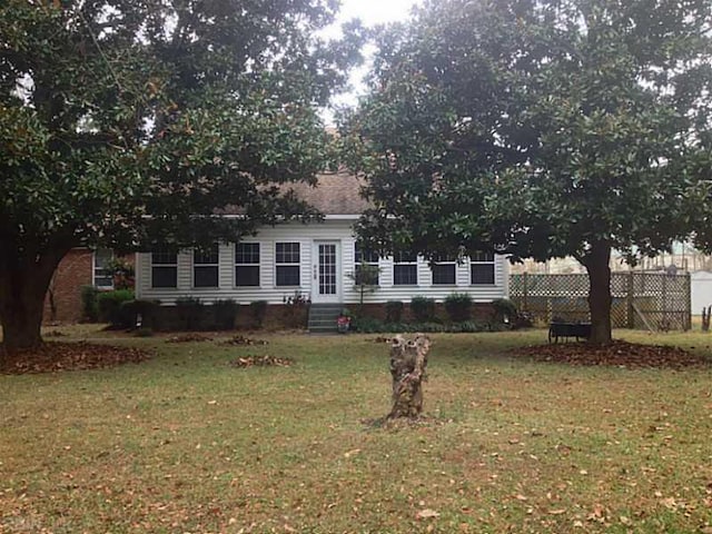 view of front of property with a front lawn and central AC