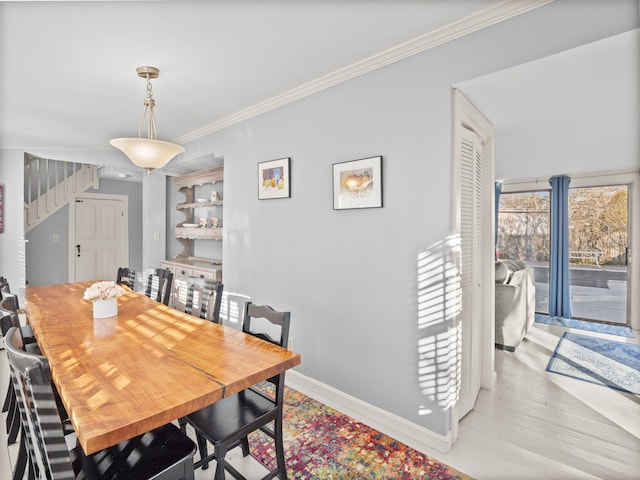 dining area featuring crown molding and light hardwood / wood-style floors