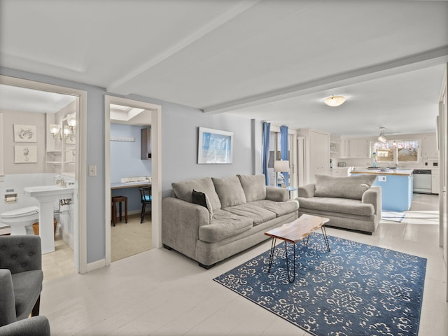 living room featuring beam ceiling and a chandelier