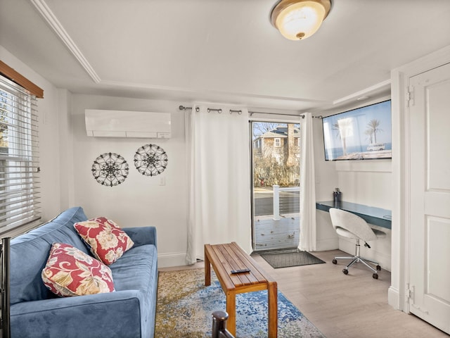 living room featuring a wealth of natural light, light hardwood / wood-style floors, and an AC wall unit