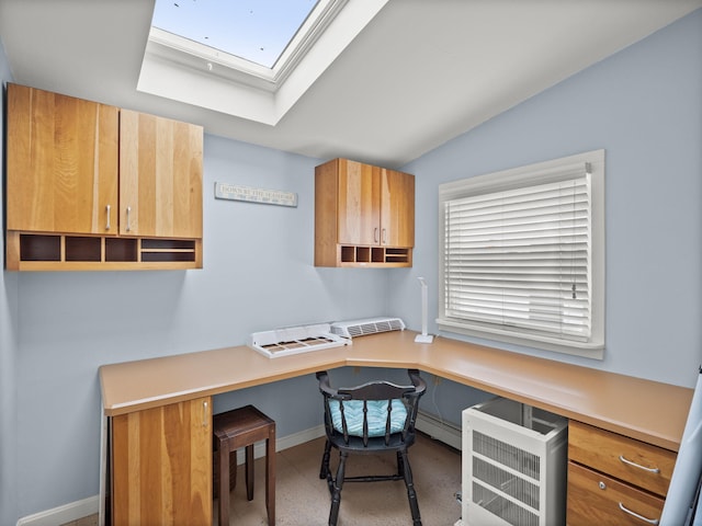 office space with vaulted ceiling with skylight and built in desk