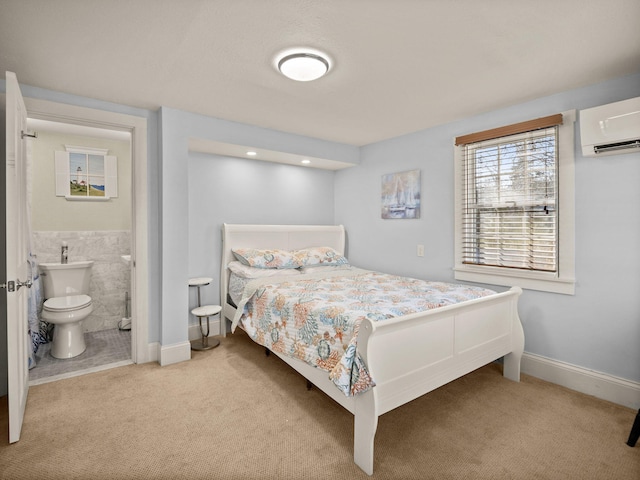 carpeted bedroom featuring ensuite bathroom and a wall mounted AC