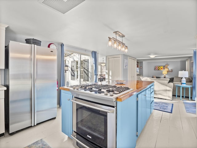 kitchen with decorative light fixtures, blue cabinetry, and appliances with stainless steel finishes