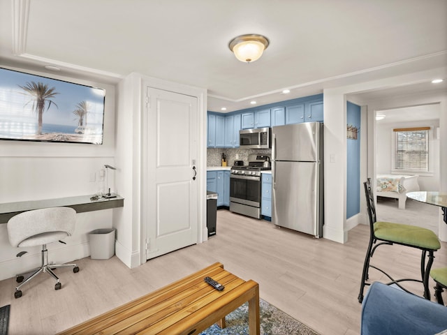 kitchen featuring tasteful backsplash, light wood-type flooring, stainless steel appliances, and blue cabinetry