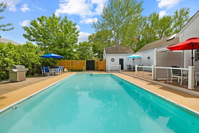 view of pool featuring area for grilling, an outdoor structure, and a patio