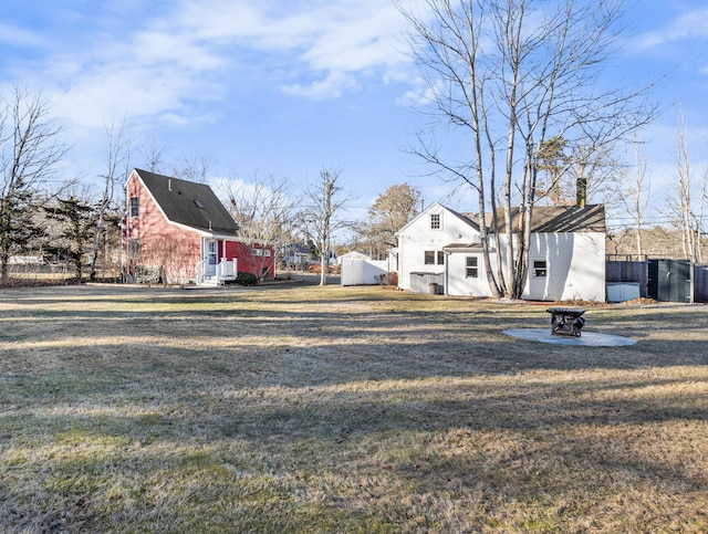 view of yard with an outdoor structure and an outdoor fire pit