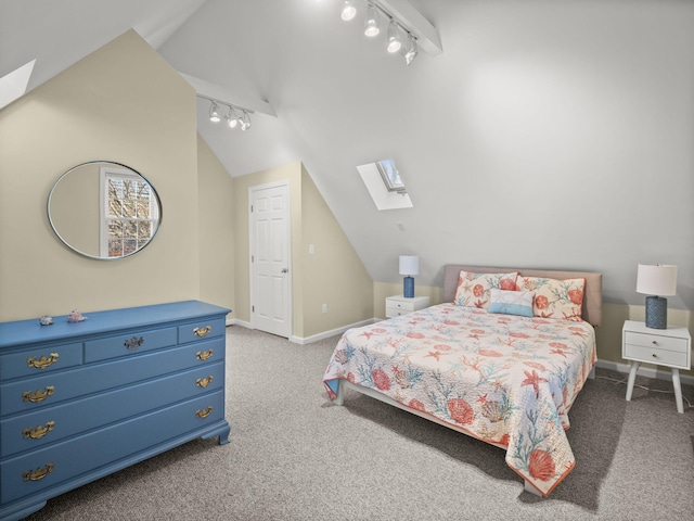 carpeted bedroom with track lighting and lofted ceiling with skylight