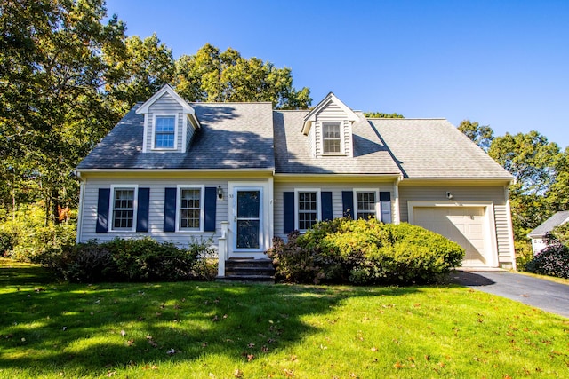 cape cod home with a front yard and a garage