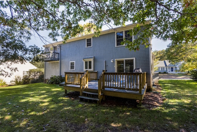 rear view of house with a lawn and a deck