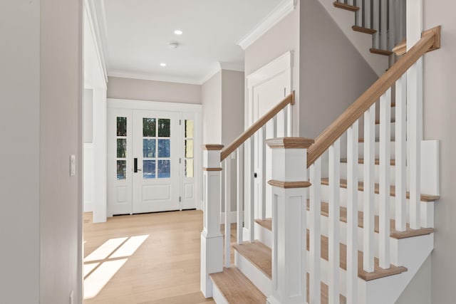 entrance foyer featuring crown molding and light hardwood / wood-style floors