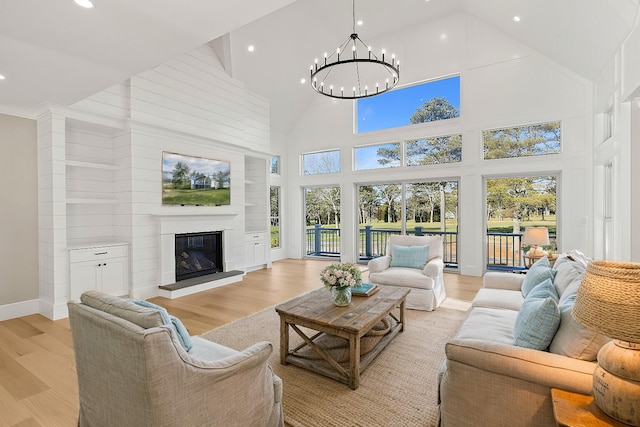 living room featuring a high ceiling, a chandelier, and light wood-type flooring