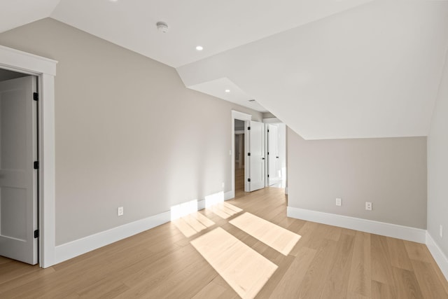 bonus room with light hardwood / wood-style floors and vaulted ceiling