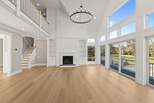 unfurnished living room with plenty of natural light, a towering ceiling, and a fireplace