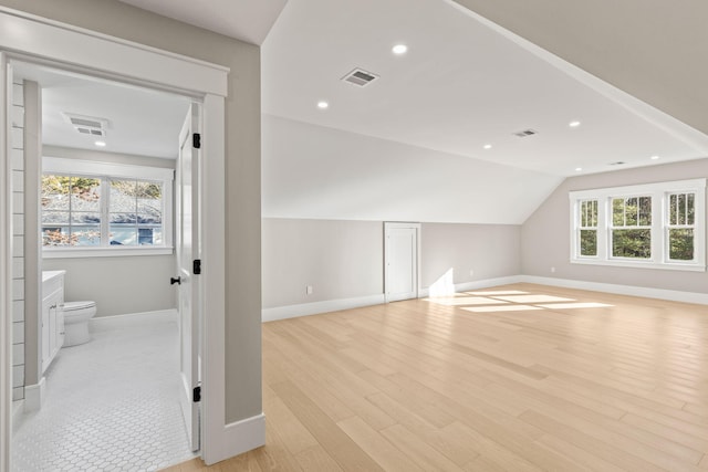 bonus room featuring light wood-type flooring and vaulted ceiling