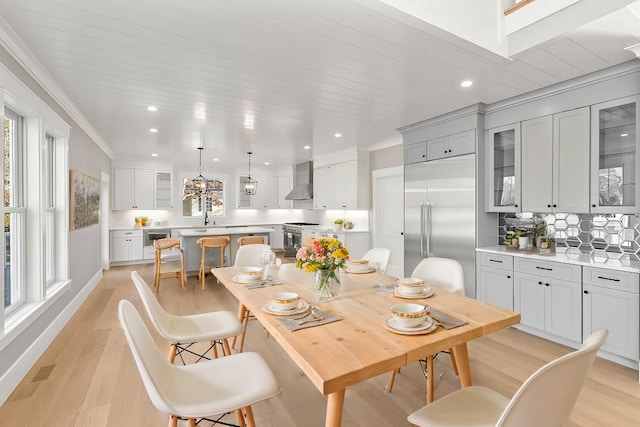 dining room with light wood-type flooring, wine cooler, plenty of natural light, and sink