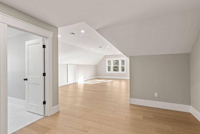 bonus room featuring light wood-type flooring and vaulted ceiling