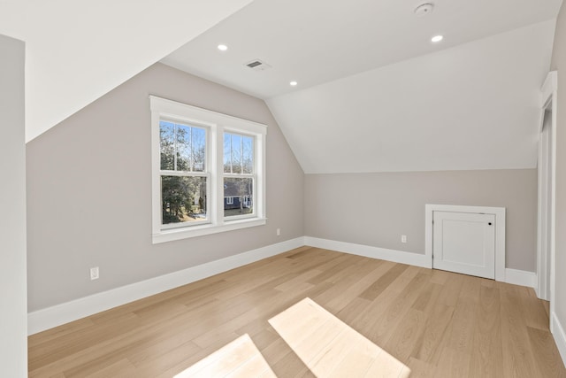 bonus room featuring light wood-type flooring and vaulted ceiling