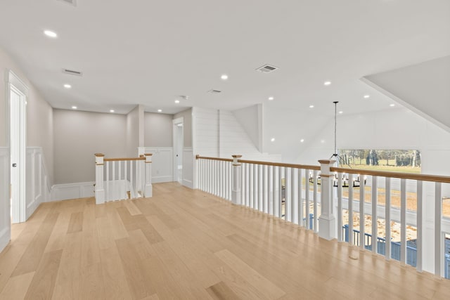 hallway with light wood-type flooring and a wealth of natural light