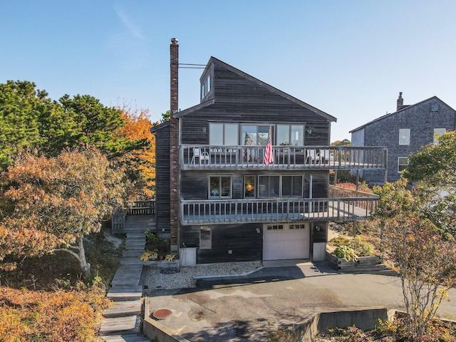 rear view of property with a balcony and a garage