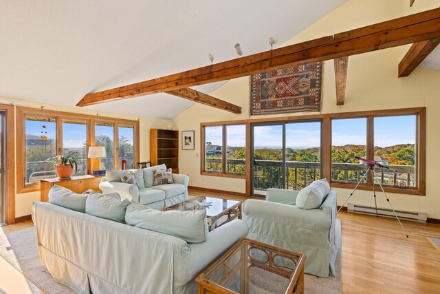 living room featuring light hardwood / wood-style floors, vaulted ceiling with beams, a baseboard heating unit, and a healthy amount of sunlight