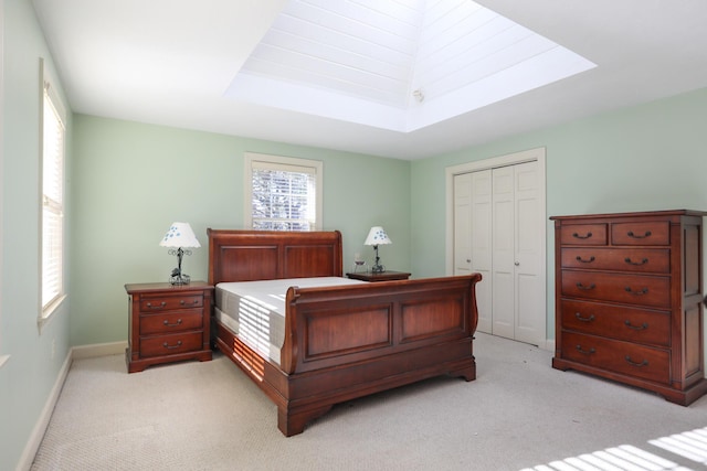 carpeted bedroom featuring multiple windows, a closet, and a skylight