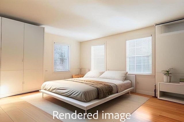 bedroom with multiple windows and light hardwood / wood-style flooring