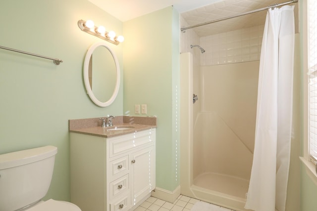 bathroom featuring vanity, toilet, walk in shower, and tile patterned flooring