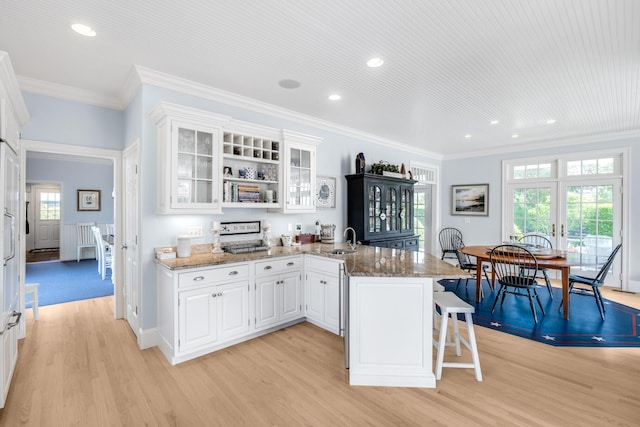 88 Champlain Rd, Chatham, MA 02633 - kitchen featuring a peninsula, light wood finished floors, recessed lighting, ornamental molding, and white cabinetry