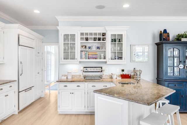 88 Champlain Rd, Chatham, MA 02633 - kitchen featuring a breakfast bar area, paneled fridge, a peninsula, light wood-style floors, and white cabinetry
