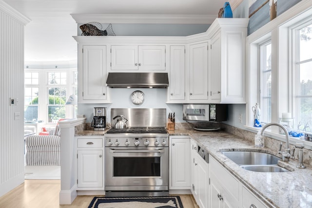 88 Champlain Rd, Chatham, MA 02633 - kitchen with under cabinet range hood, stainless steel appliances, light wood finished floors, ornamental molding, and white cabinetry