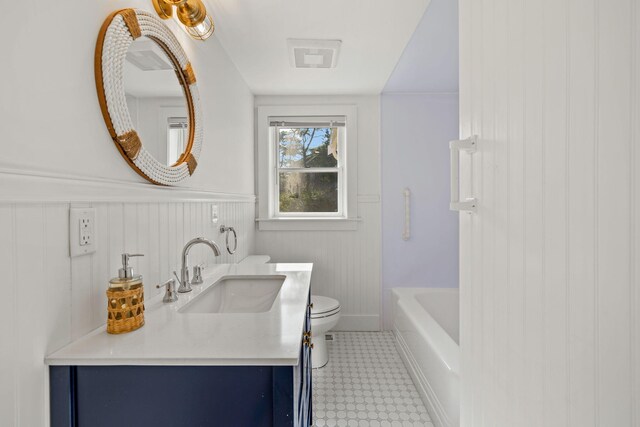 72 Forest Beach Rd, South Chatham, MA 02659 - bathroom featuring toilet, tile patterned floors, vanity, and a wainscoted wall