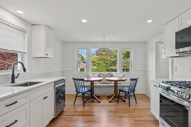 72 Forest Beach Rd, South Chatham, MA 02659 - kitchen with a sink, appliances with stainless steel finishes, plenty of natural light, wainscoting, and light wood finished floors