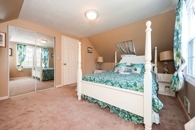 bedroom with a closet, lofted ceiling, and carpet flooring