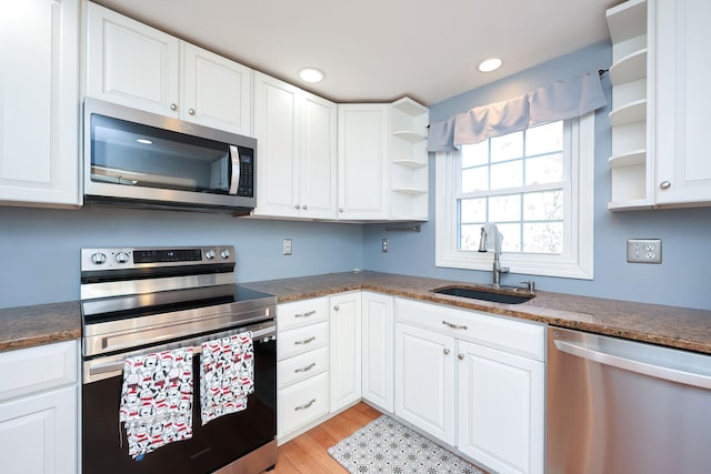 kitchen featuring light hardwood / wood-style floors, white cabinets, appliances with stainless steel finishes, and sink