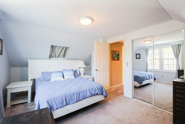 bedroom with a closet, vaulted ceiling, and carpet flooring