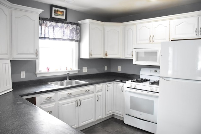 96 Manchester Ave, Oak Bluffs, MA 02557 - kitchen with dark countertops, a sink, white cabinetry, and white appliances