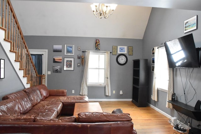 96 Manchester Ave, Oak Bluffs, MA 02557 - living room featuring stairs, a chandelier, vaulted ceiling, light wood finished floors, and baseboards