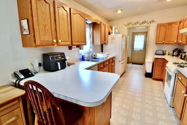 62 Jernegan Ave, Edgartown, MA 02539 - kitchen with white appliances, a sink, light countertops, and a kitchen breakfast bar