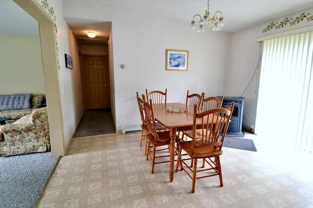 62 Jernegan Ave, Edgartown, MA 02539 - dining space with a chandelier, a wood stove, baseboard heating, and light flooring