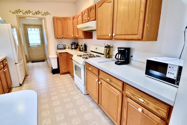 62 Jernegan Ave, Edgartown, MA 02539 - kitchen with white appliances, under cabinet range hood, light floors, and light countertops